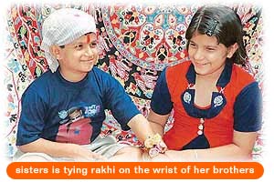 sisters is tying rakhi on the wrist of her brothers